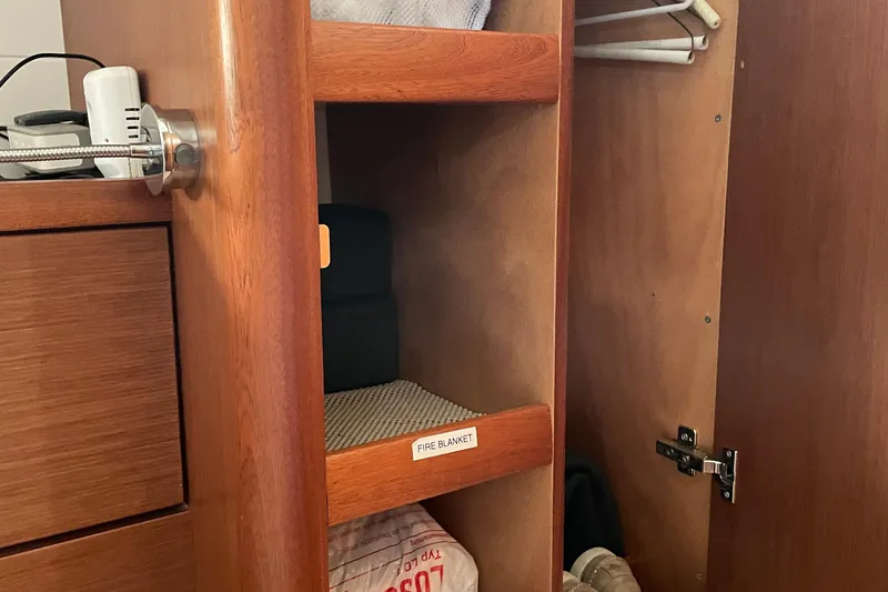 Slide: The Image of Wooden cabinet interior on 2013 Bavaria Vision 42 yacht, featuring shelves and a fire blanket. - 61