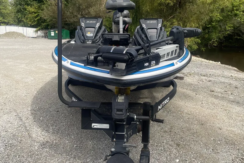 Slide: The Image of 2021 Nitro Z20 boat on trailer, parked on gravel near trees. - 3