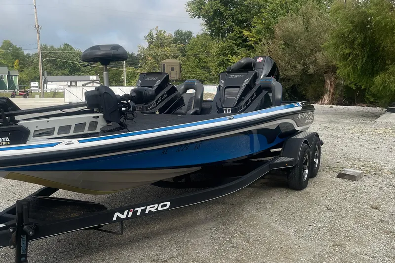 Slide: The Image of 2021 Nitro Z20 boat on trailer, parked outdoors, featuring sleek design and dual motors. - 6