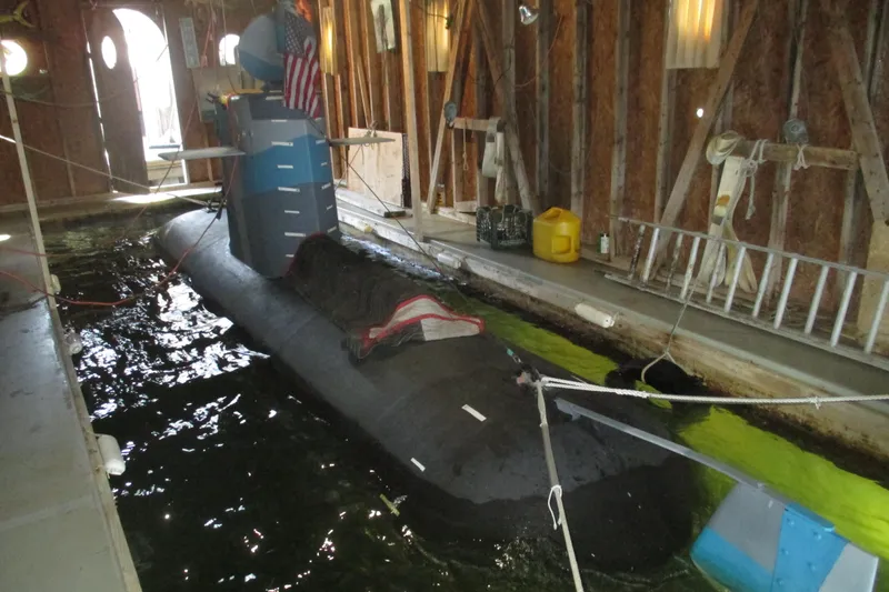 Slide: The Image of 2023 Submarine 28 Composite Construction in a wooden dock, partially submerged. - 3