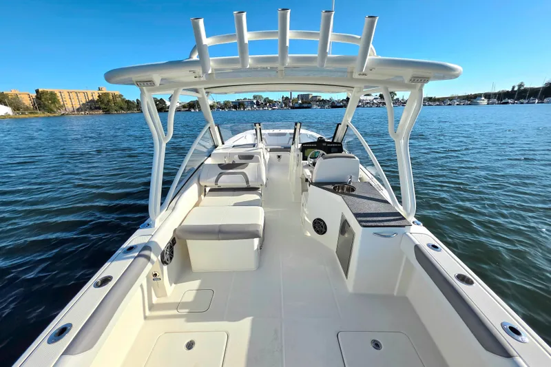 Slide: The Image of 2018 World Cat 280 DC-X boat on calm water, showcasing spacious deck and seating. - 15