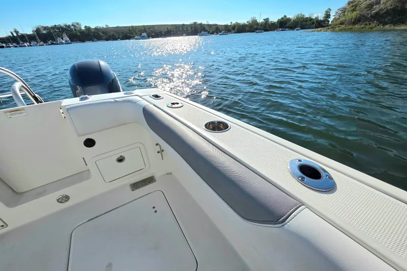Slide: The Image of 2018 World Cat 280 DC-X boat on water, featuring sleek deck design and scenic lake view. - 17
