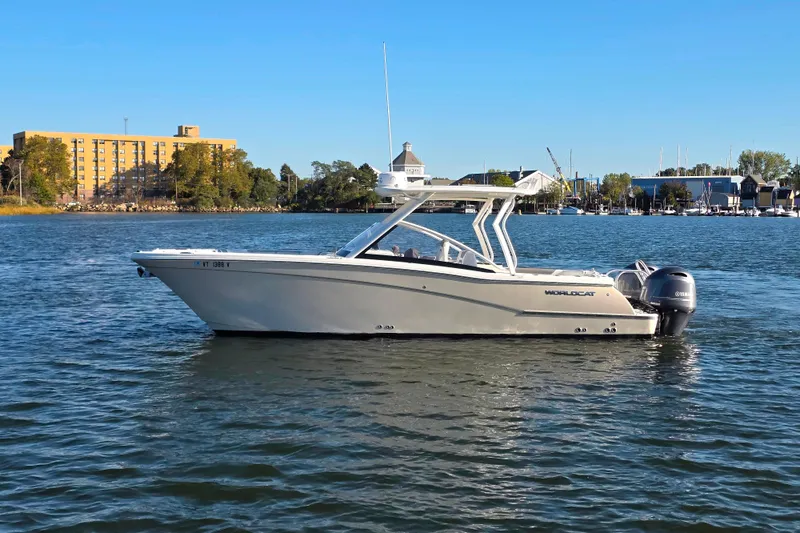Slide: The Image of 2018 World Cat 280 DC-X boat on calm water, cityscape background. - 2