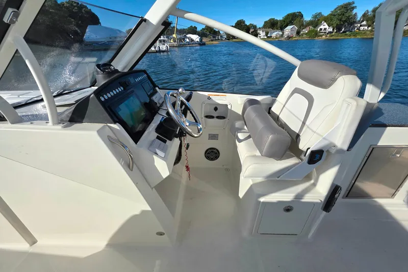 Slide: The Image of 2018 World Cat 280 DC-X boat cockpit with steering wheel and comfortable seating. - 30