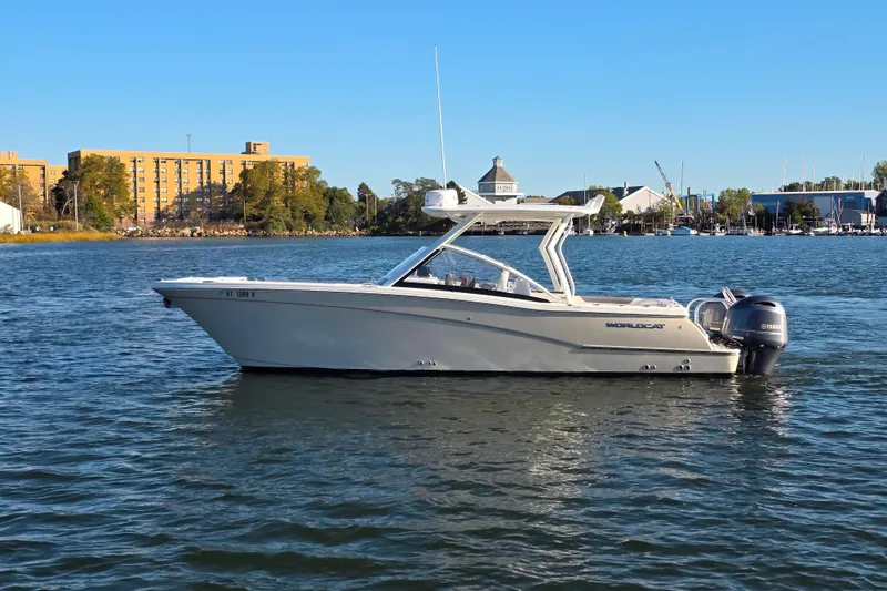 Slide: The Image of 2018 World Cat 280 DC-X boat on calm water with cityscape background. - 33