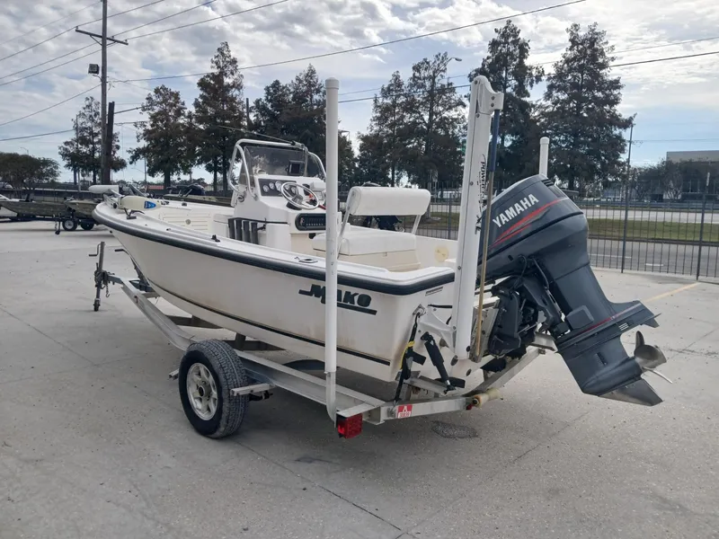 Slide: The Image of 2001 Mako 171 boat on trailer with Yamaha outboard motor, parked outdoors. - 10