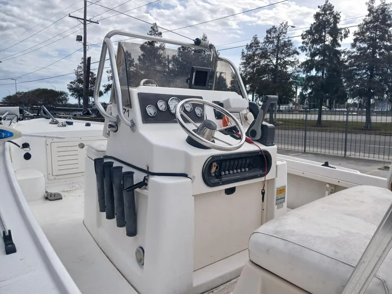 Slide: The Image of 2001 Mako 171 boat console with steering wheel and gauges, set against a marina backdrop. - 5