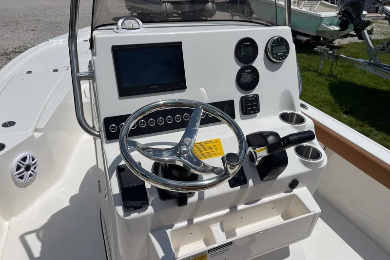 Slide: The Image of 2026 Key West 210 Bay Reef boat console with steering wheel and navigation controls. - 15