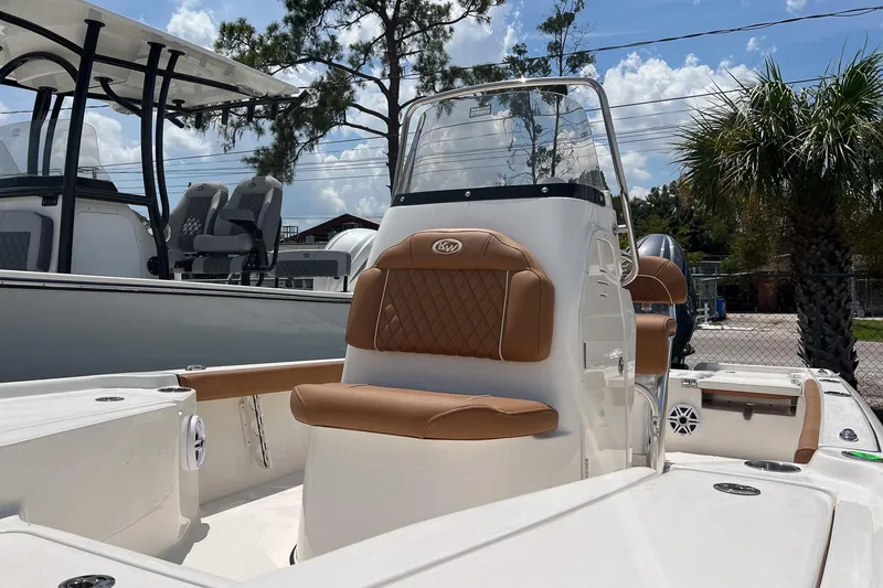 Slide: The Image of 2026 Key West 210 Bay Reef boat with tan seating, docked under a sunny sky. - 2