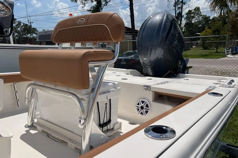 Slide: The Image of 2026 Key West 210 Bay Reef boat interior with tan seating and powerful outboard motor. - 3
