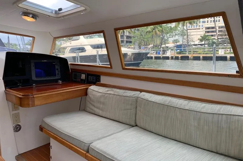 Slide: The Image of 1999 Little Harbor 51 Pilothouse interior with wooden table, cushioned seating, and navigation equipment. - 15
