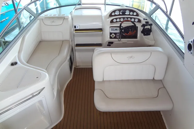 Slide: The Image of Interior of a 2000 Monterey 302 Cruiser with white seating and wooden flooring. - 29