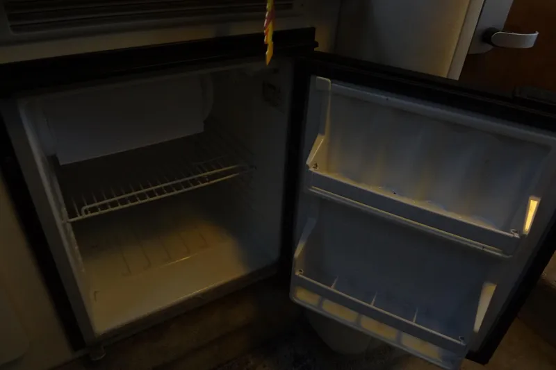Slide: The Image of Open refrigerator inside a 2000 Monterey 302 Cruiser boat, showing empty shelves. - 41
