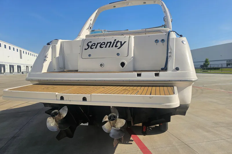 Slide: The Image of Rear view of a 2000 Monterey 302 Cruiser boat named "Serenity" on a sunny day. - 5