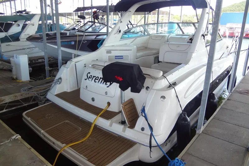 Slide: The Image of 2000 Monterey 302 Cruiser docked, featuring spacious deck and seating area. - 7