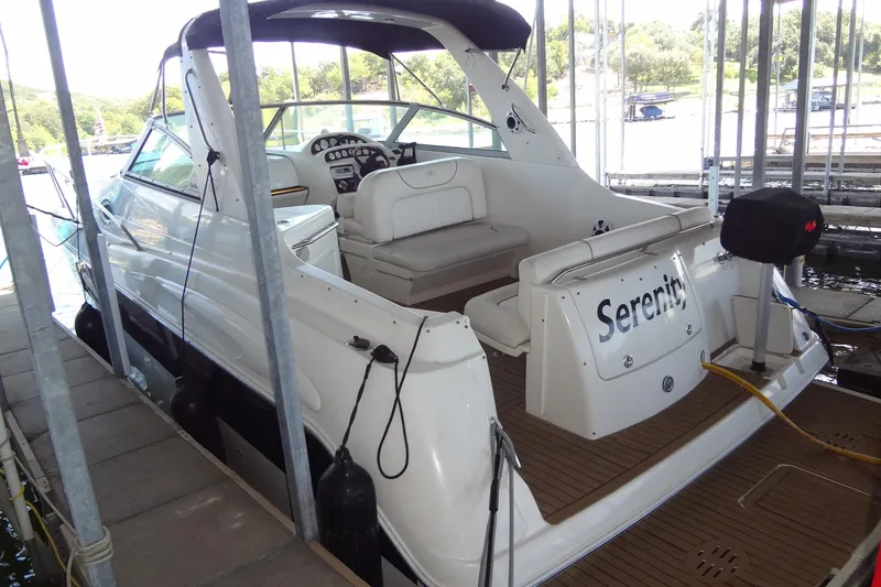 Slide: The Image of 2000 Monterey 302 Cruiser docked, featuring spacious seating and "Serenity" name on the stern. - 9