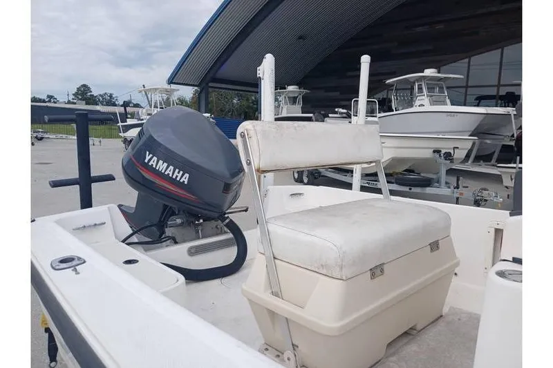 Slide: The Image of 2001 Mako 171 Center Console boat with Yamaha outboard motor, docked near other boats. - 5