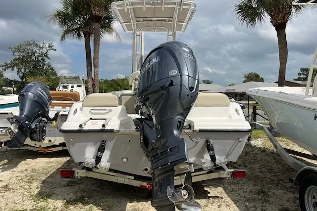 Slide: The Image of 2026 Key West 189 FS boat with outboard motor, parked on sandy ground. - 1