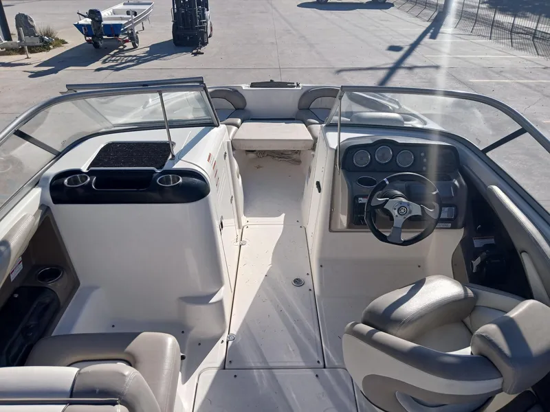 Slide: The Image of 2010 Yamaha Boats 242 Limited on trailer, sleek design, black and white exterior. - 2