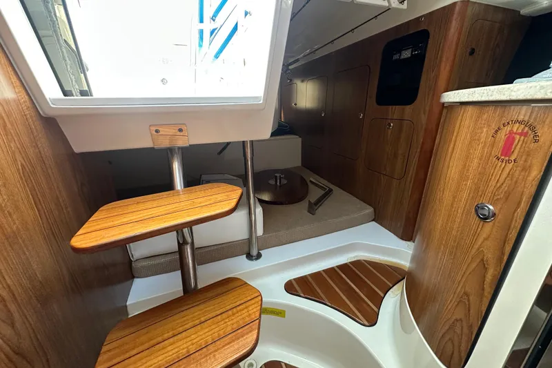 Slide: The Image of 2010 Pursuit OS 315 Offshore cabin interior with wooden steps and seating area. - 14