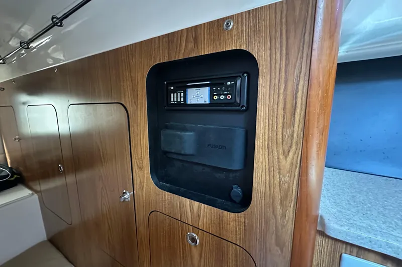 Slide: The Image of Interior of 2010 Pursuit OS 315 Offshore with wood paneling and audio system. - 16
