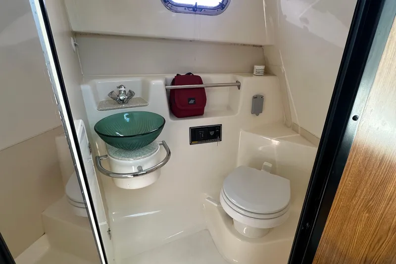 Slide: The Image of 2010 Pursuit OS 315 Offshore boat bathroom with modern fixtures and glass sink. - 18