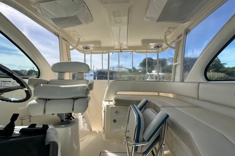 Slide: The Image of Interior of 2010 Pursuit OS 315 Offshore boat with white seating and steering wheel. - 19