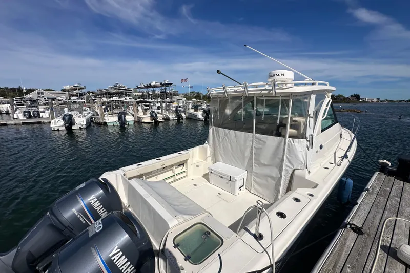 Slide: The Image of 2010 Pursuit OS 315 Offshore boat docked with Yamaha engines, marina background. - 21