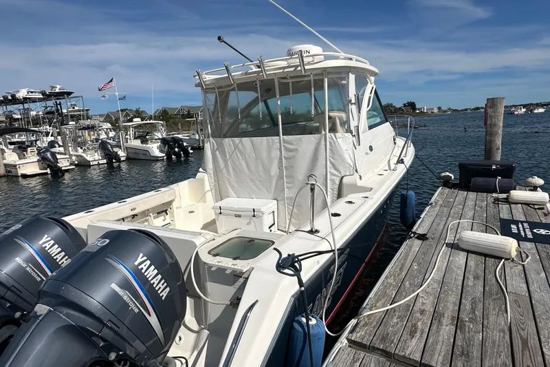Slide: The Image of 2010 Pursuit OS 315 Offshore boat docked with twin Yamaha engines. - 3