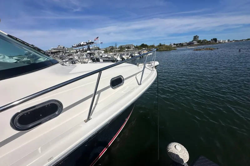 Slide: The Image of 2010 Pursuit OS 315 Offshore boat docked on calm water under blue sky. - 4