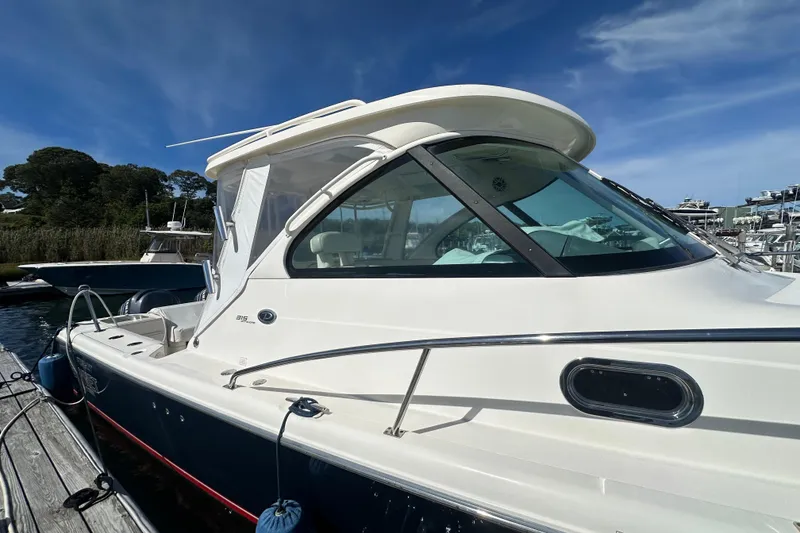 Slide: The Image of 2010 Pursuit OS 315 Offshore boat docked under clear blue sky. - 5