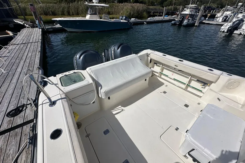 Slide: The Image of 2010 Pursuit OS 315 Offshore boat docked, featuring spacious deck and twin Yamaha engines. - 6