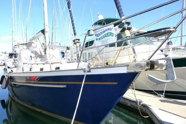 Slide: The Image of 2002 Tayana 460 Vancouver Pilothouse yacht docked in marina, blue hull, sunny day. - 103