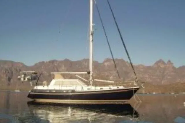 Slide: The Image of 2002 Tayana 460 Vancouver Pilothouse yacht on calm water with mountainous backdrop. - 106