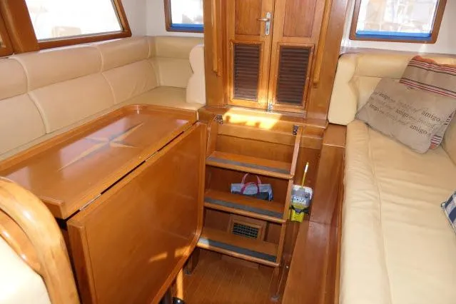 Slide: The Image of Interior of 2002 Tayana 460 Vancouver Pilothouse with wooden table and beige seating. - 12
