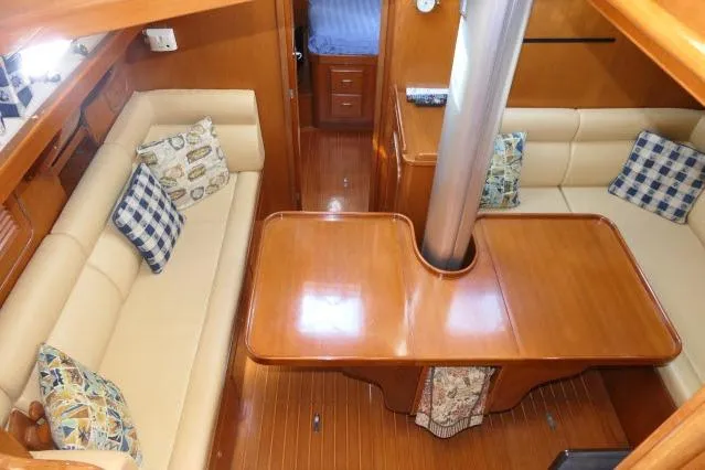 Slide: The Image of Interior of 2002 Tayana 460 Vancouver Pilothouse with wooden table and cushioned seating. - 16