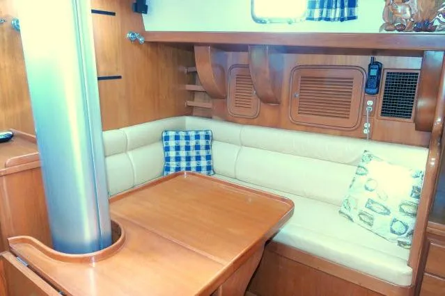 Slide: The Image of 2002 Tayana 460 Vancouver Pilothouse interior with wooden dining area and cushioned seating. - 21