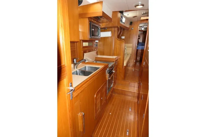 Slide: The Image of Interior of 2002 Tayana 460 Vancouver Pilothouse with wooden cabinetry and modern kitchen amenities. - 33