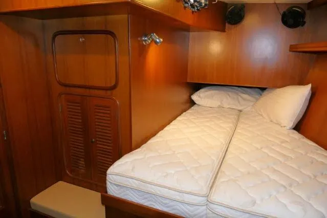 Slide: The Image of Cozy cabin interior of 2002 Tayana 460 Vancouver Pilothouse with wooden finish and comfortable bedding. - 43