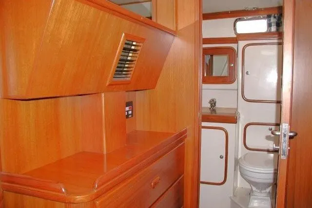 Slide: The Image of Interior of 2002 Tayana 460 Vancouver Pilothouse with wooden cabinetry and compact bathroom. - 48