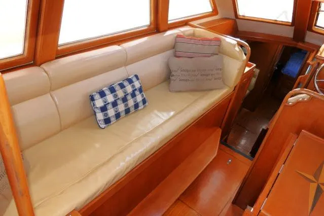 Slide: The Image of Interior of 2002 Tayana 460 Vancouver Pilothouse with cushioned seating and decorative pillows. - 5