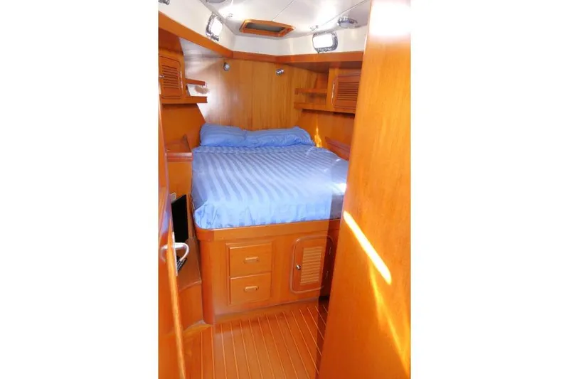 Slide: The Image of Cozy cabin interior of 2002 Tayana 460 Vancouver Pilothouse with wooden finish and blue bedding. - 50