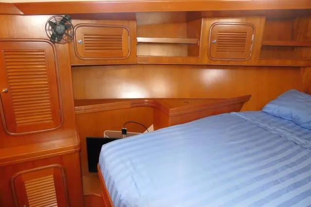 Slide: The Image of Cozy cabin interior of 2002 Tayana 460 Vancouver Pilothouse with wooden finish and blue bedding. - 53