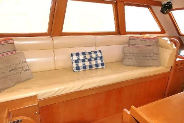 Slide: The Image of Interior of 2002 Tayana 460 Vancouver Pilothouse with cushioned seating and decorative pillows. - 6