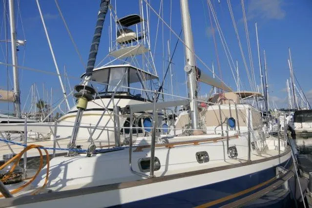 Slide: The Image of 2002 Tayana 460 Vancouver Pilothouse sailboat docked in a marina under clear blue skies. - 83