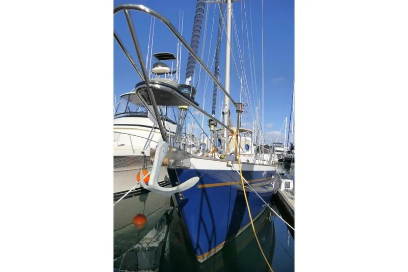 Slide: The Image of 2002 Tayana 460 Vancouver Pilothouse sailboat docked in marina, blue hull, clear sky. - 84