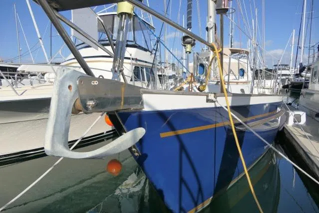Slide: The Image of 2002 Tayana 460 Vancouver Pilothouse yacht docked in marina, blue hull, visible anchor. - 85