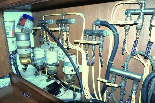 Slide: The Image of Engine room of 2002 Tayana 460 Vancouver Pilothouse with complex piping and filters. - 96