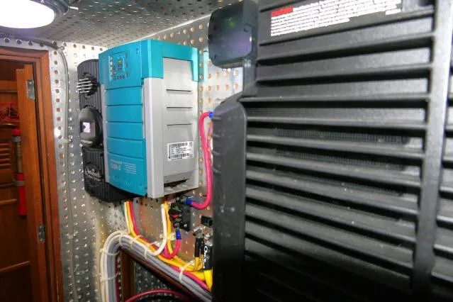 Slide: The Image of Electrical system inside 2002 Tayana 460 Vancouver Pilothouse, featuring wiring and control panels. - 99