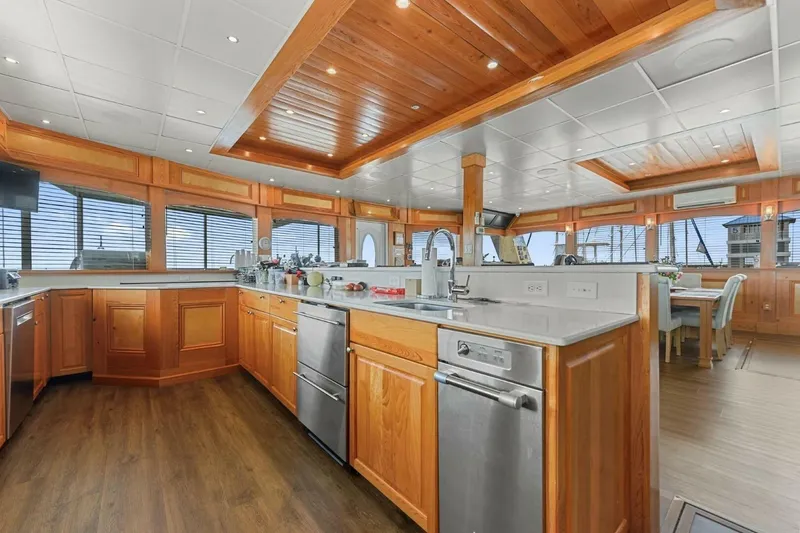 Slide: The Image of Luxurious kitchen interior of 2018 Avenger Custom Catamaran, featuring wood finishes and modern appliances. - 20